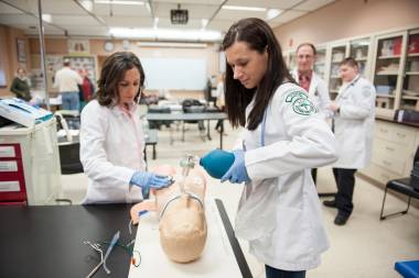 QCC students practice healthcare techniques on dummy