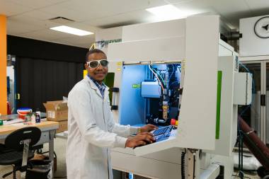 Man stands at machine using lasers
