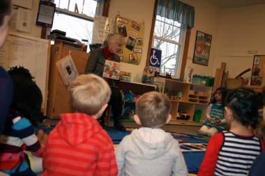 Staff member reading to children in Children's School
