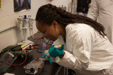 QCC student fills beakers with solution