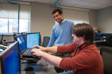 QCC instructor helps student with programming laptop